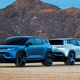 A photo of two Fisker Ocean electric SUVs parked back to back on sand.
